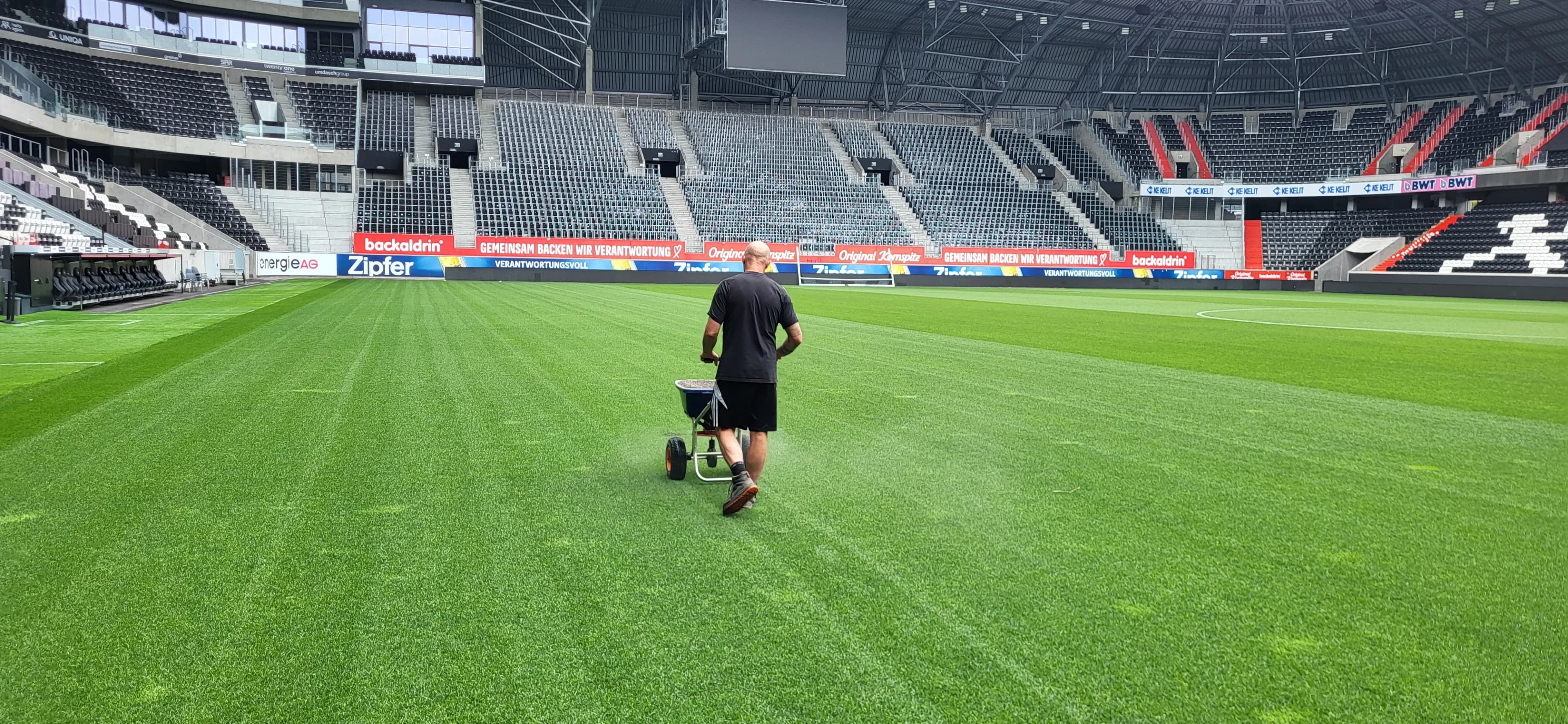 Greenkeeper bei der Rasenpflege im Stadion